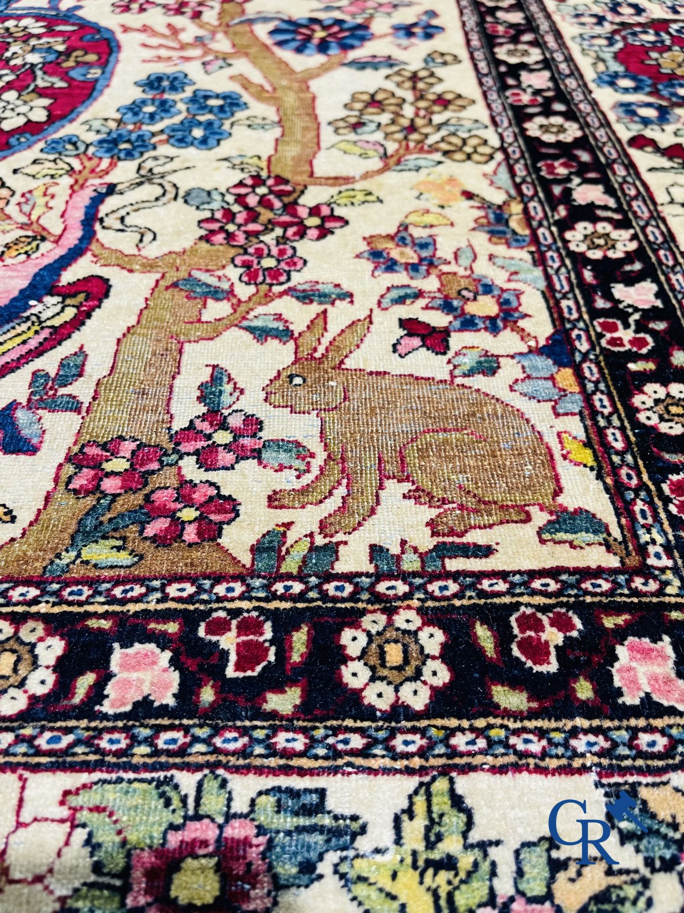 Oriental carpets. Iran. Persian carpet with a flower vase, birds and rabbits in a floral decor.