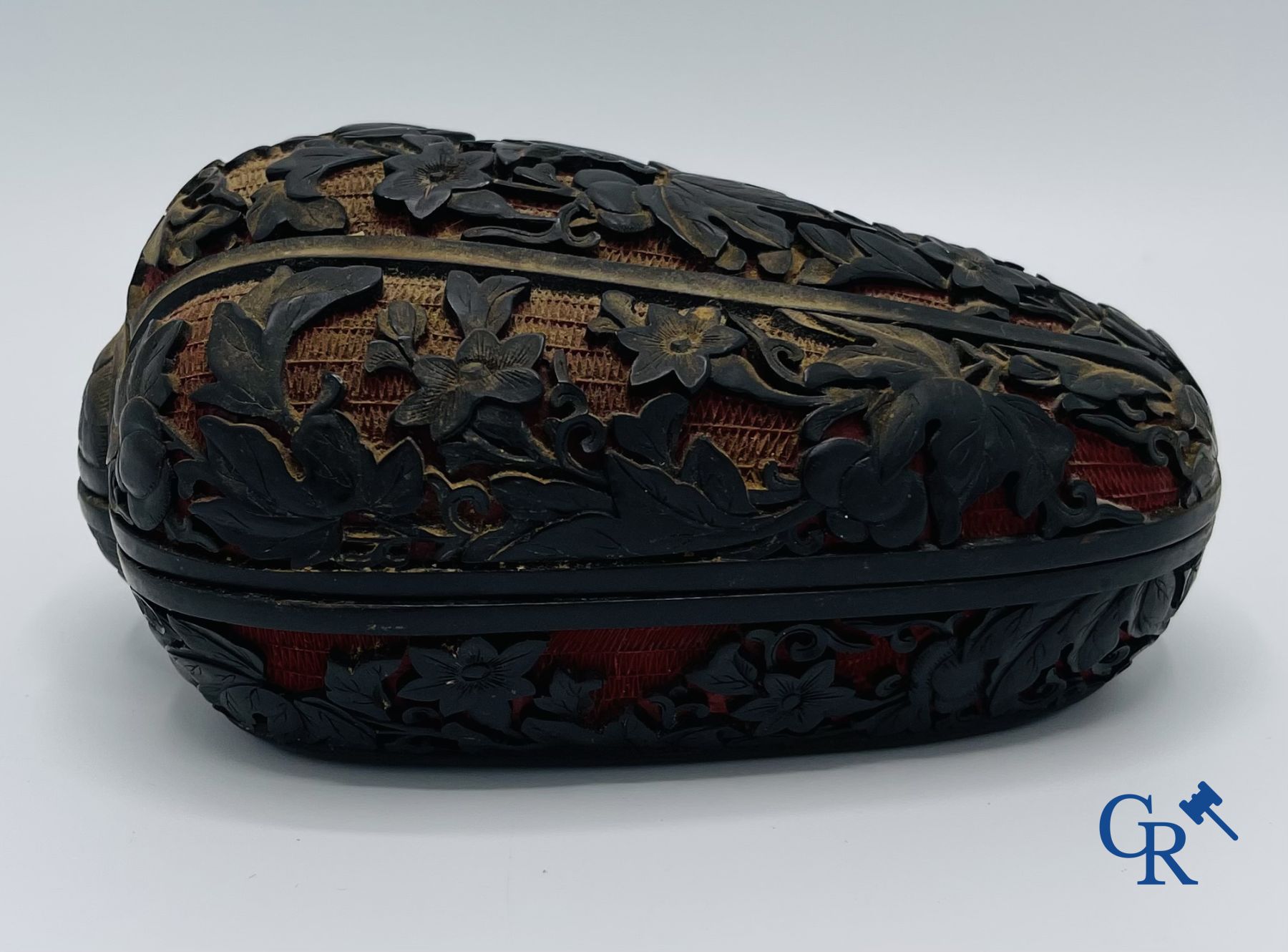 Asian Art: A finely carved Chinese lid box in black lacquer on a red background.