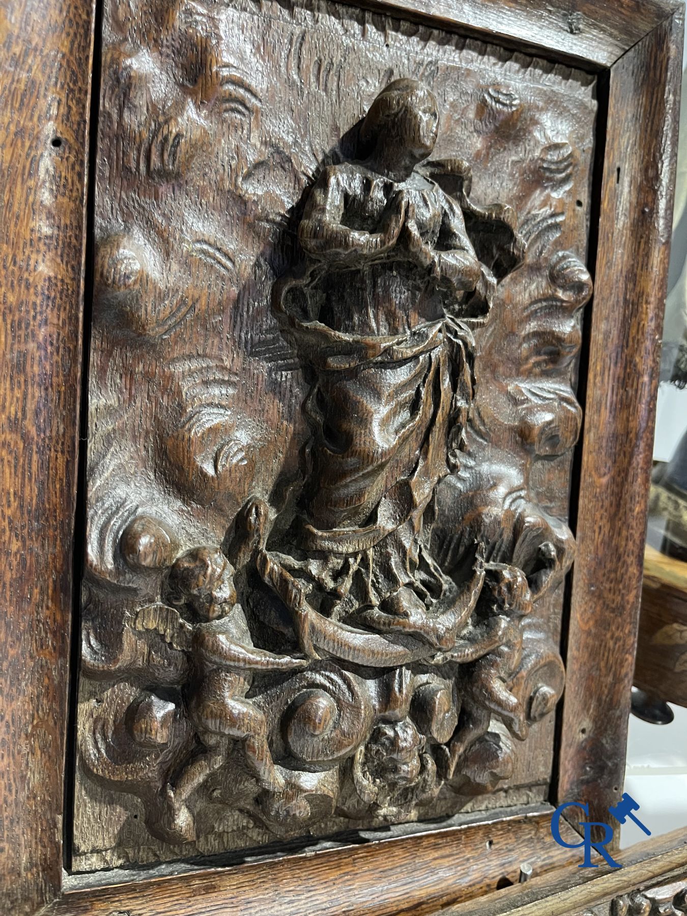 A lot with various antique wood sculptures and an antique book on a reading table.