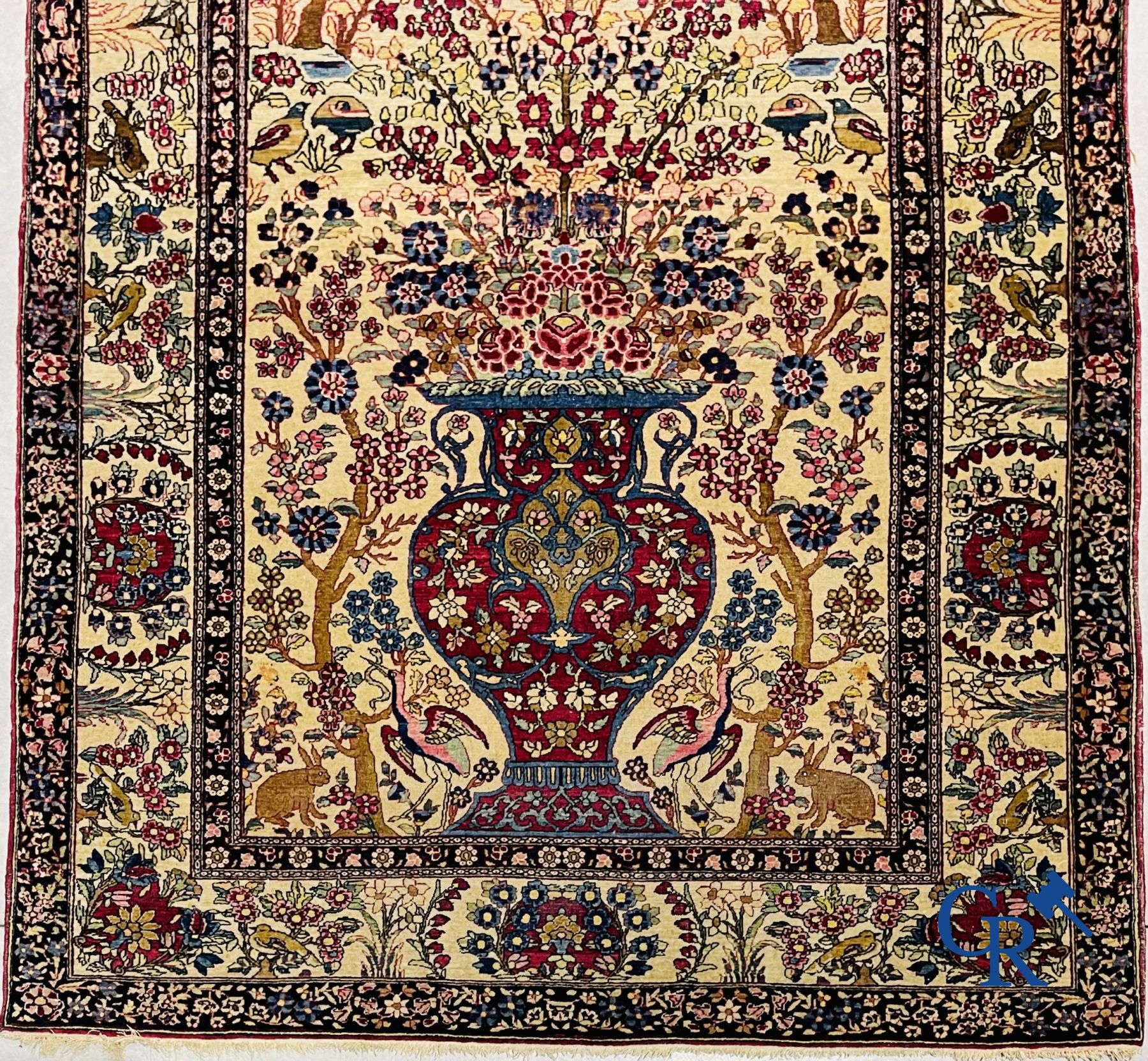 Oriental carpets. Iran. Persian carpet with a flower vase, birds and rabbits in a floral decor.