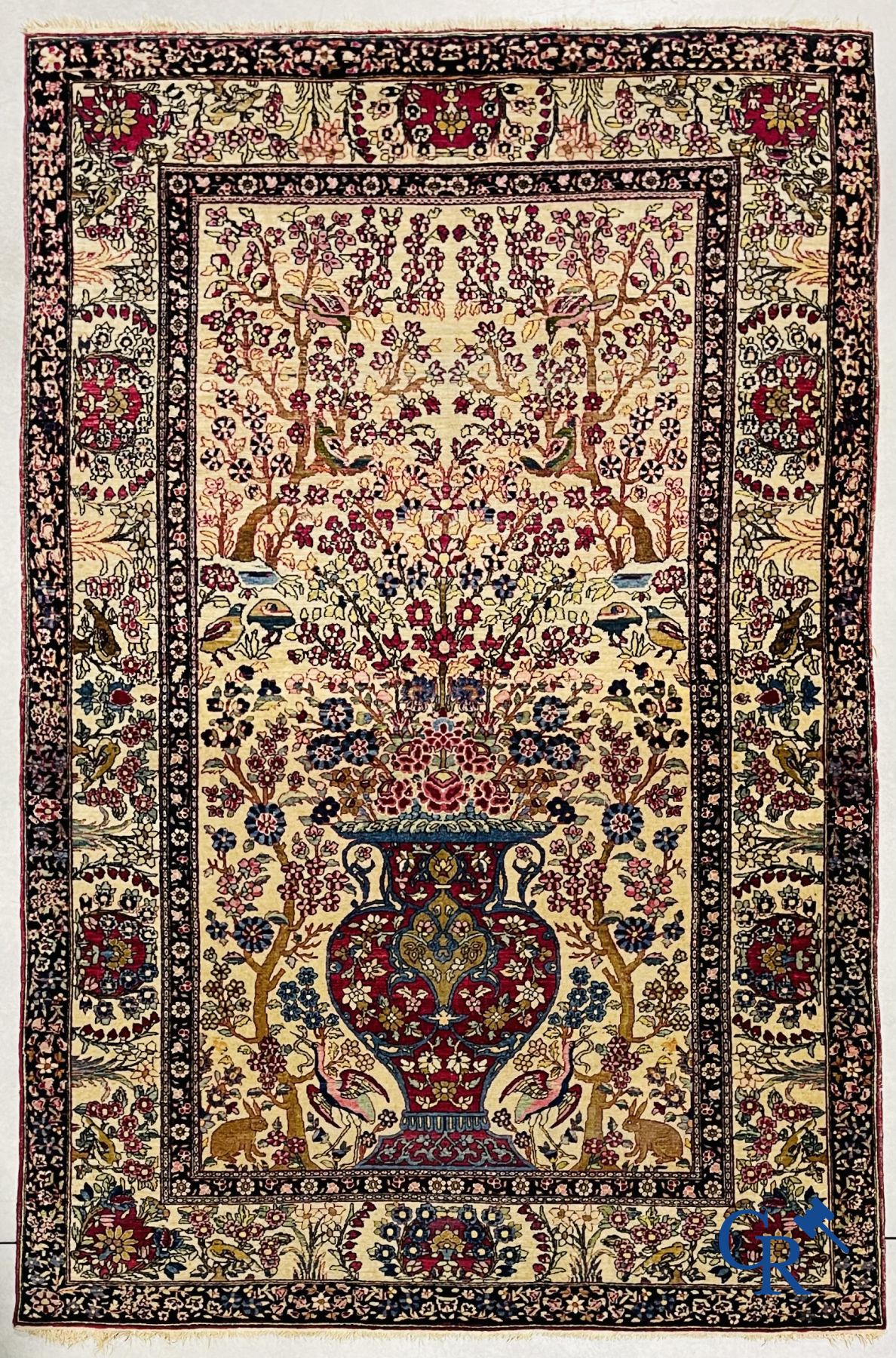 Oriental carpets. Iran. Persian carpet with a flower vase, birds and rabbits in a floral decor.